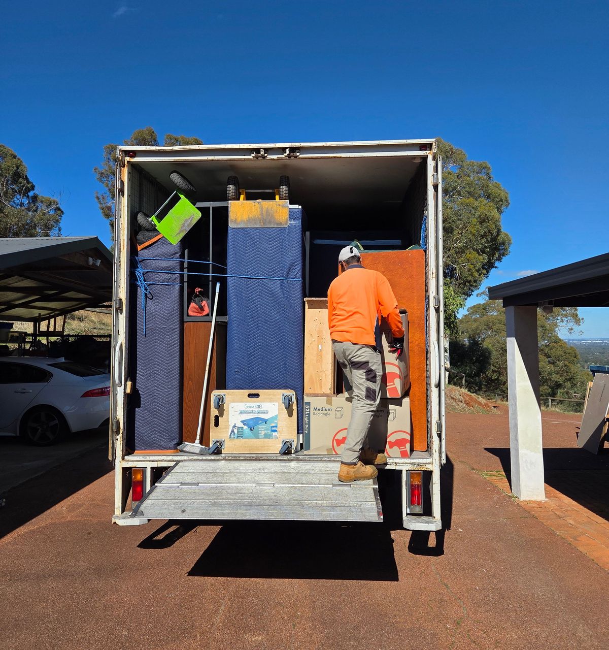 Removalist loading boxes and wrapped furniture into a truck